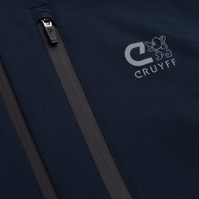 Close-up of a dark navy softshell jacket with a vertical zippered pocket and a light gray embroidered CRUYFF logo on the chest.