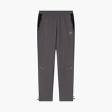 A pair of dark gray athletic pants with black side panels, a small white logo on the left thigh, and adjustable drawstring hems, shown against a plain white background.