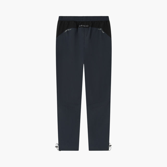 A pair of dark navy blue athletic pants with a black elastic waistband and small silver metal clips at the lower hems, shown against a plain white background.