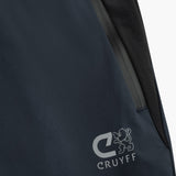 Close-up of a dark navy blue jacket or outerwear piece with a visible gray zipper and a white Cruyff logo printed near the lower left area.