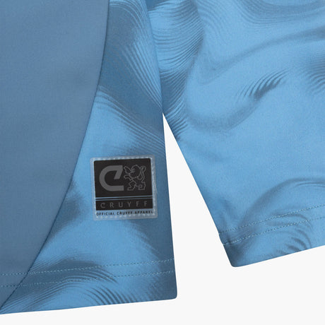 Close-up of blue sports shorts with a visible brand label on a white background