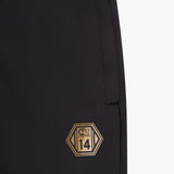 Black pants with a gold and black logo on a white background